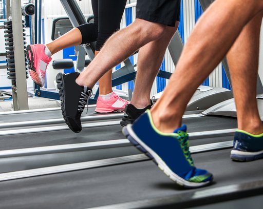 Group-of-legs-wearing-sneakers-running-on-treadmill